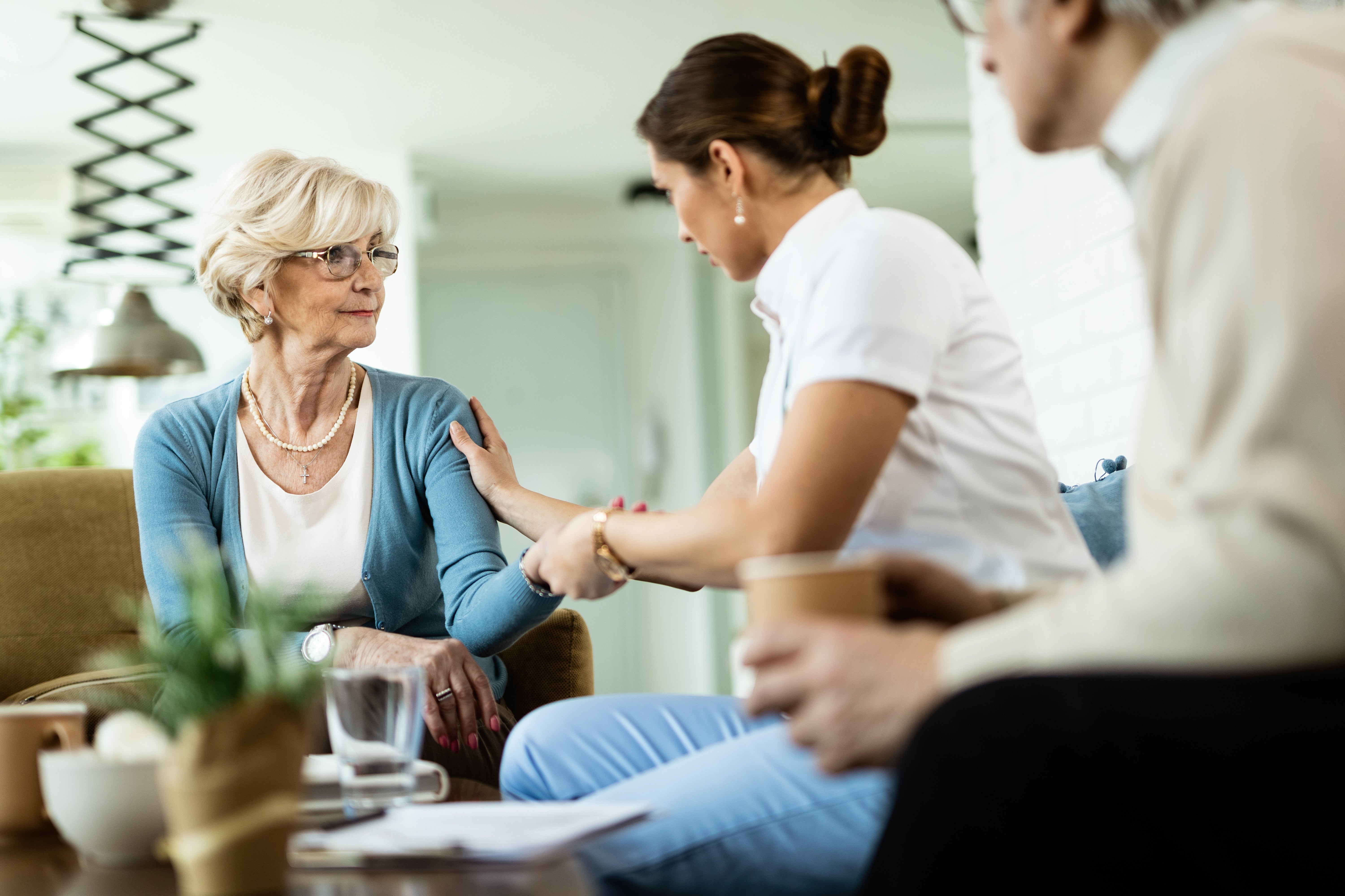 Woman comforting an elderly woman in a home setting, respite care near me