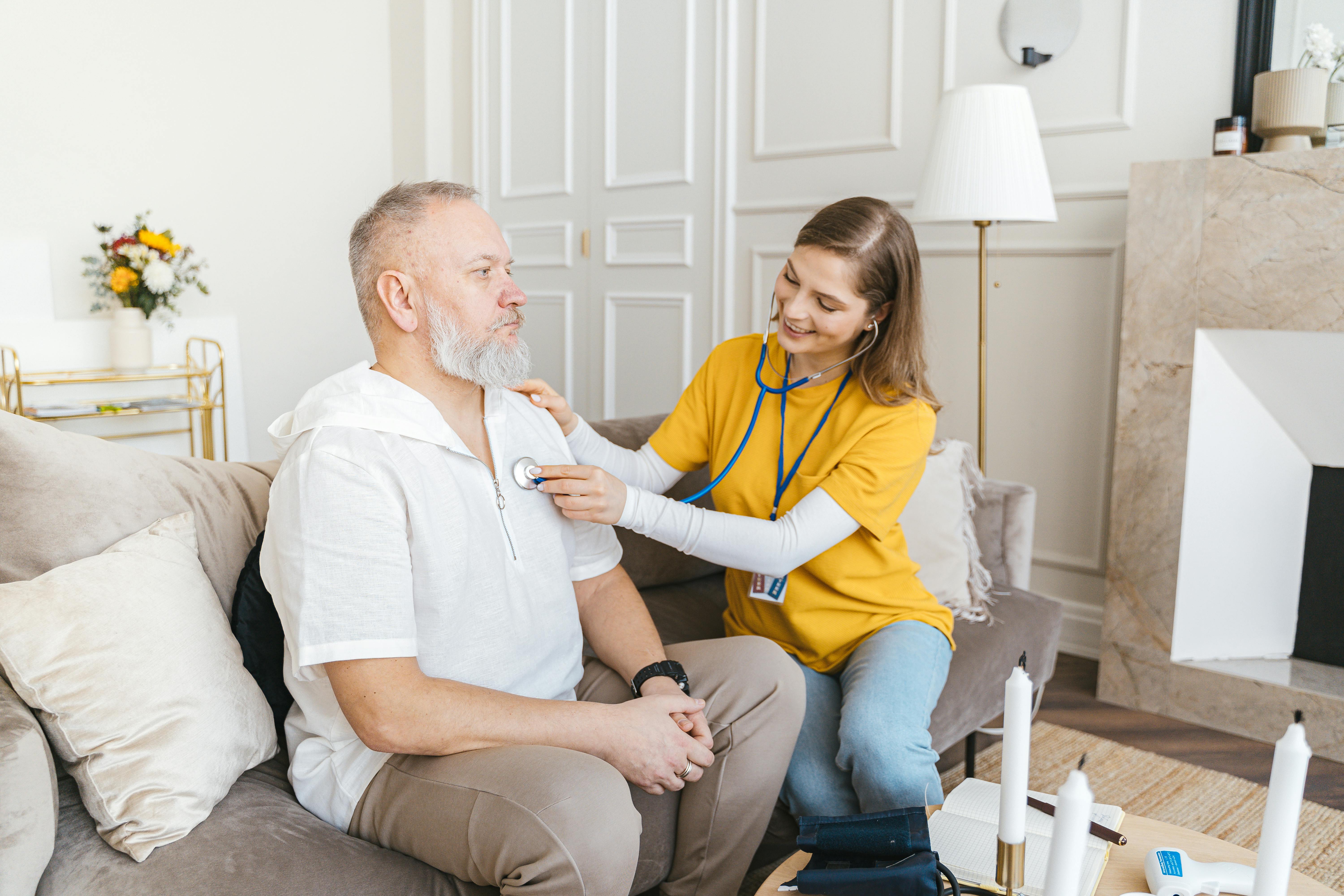 Physician examining a patient in a home setting, health care physician